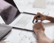 a person is typing on a laptop with their finger pointing at the keyboard