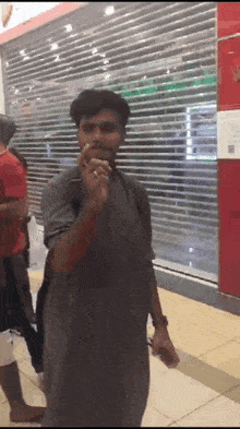 a man smoking a cigarette in front of a store with a sign that says ' closed ' on it