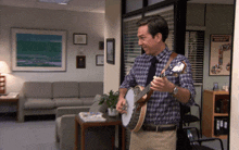 a man playing a banjo in a waiting room with a poster on the wall that says " making the best of it "