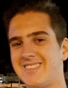 a close up of a young man 's face smiling .