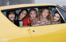 a group of young men in a yellow car