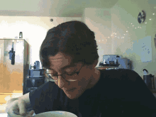 a man with glasses is eating from a bowl