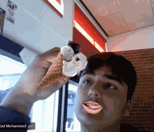 a man is holding an ice cream cone with a fake face on his face