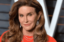 a close up of a woman 's face wearing a red shirt and earrings