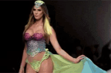 a woman is walking down a runway wearing a very colorful outfit