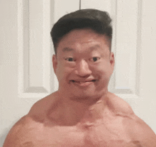 a shirtless man is making a funny face in front of a white door .