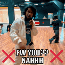 a man in a white jacket is dancing in front of a sign that says fw you ? nahhh