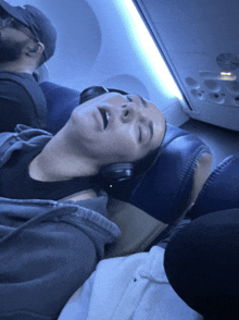 a man and a woman are sleeping on an airplane