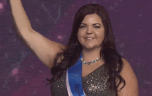 a woman in a silver dress with a blue sash around her neck that says miss canada