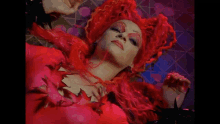 a woman with red hair is laying on the floor with her head on the floor .