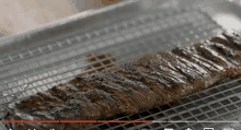 a large piece of meat is cooking on a grill