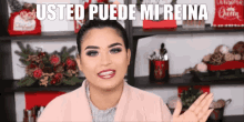 a woman is standing in front of a shelf with christmas decorations and the words usted puede mi reina above her