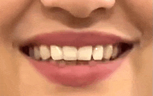 a close up of a woman 's mouth with her teeth visible .