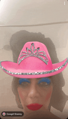 a woman wearing a pink cowboy hat with rhinestones on it