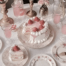 a table topped with plates , glasses , candles , and a cake .