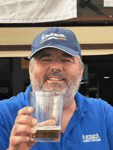 a man wearing a vespa hat is holding a glass