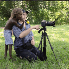 a man is pointing at a camera while a child looks on