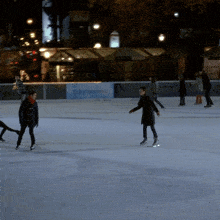 a group of people are ice skating on a rink with a sign that says ' ice ' on it