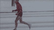 a person running in the snow with a red shirt that says ' ii ' on it