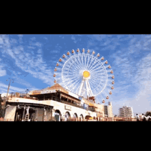 a large ferris wheel is in front of a building with a sign that says ' a ' on it