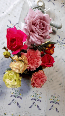 a bunch of flowers on a table with a purple rose in the center