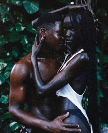 a man and woman are hugging each other and the woman is wearing a white top