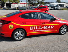 a red car with bill mar landscape company written on the side