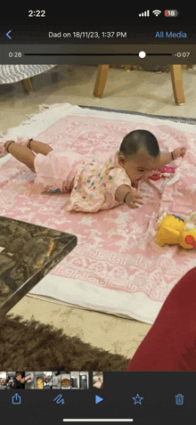 a baby is laying on a pink blanket in a video taken on 18/11/23 at 1:37 pm