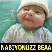 a baby wearing a white hat with the words nabiyonuzz beaa underneath