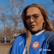 a woman wearing sunglasses and a blue jacket with a badge that says ' united states olympics ' on it