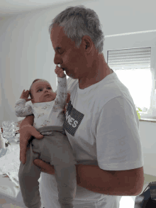 a man holding a baby wearing a t-shirt that says jones