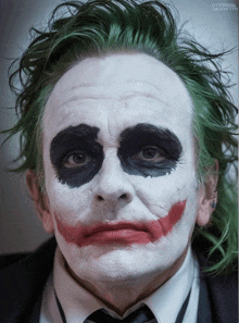 a close up of a man 's face with a joker make up