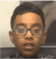 a close up of a young boy wearing glasses .