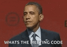 a man in a suit and tie is standing in front of a red background and asking what is the meeting code .