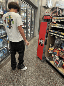 a man standing in front of a coca cola display in a store