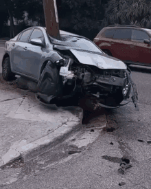 a car that has crashed into a power pole on the side of the road