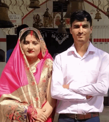 a man and a woman are posing for a picture in front of a sign that says ' shree ram ' on it