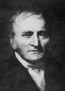 a black and white portrait of a man in a suit and tie