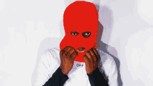 a man wearing a red ski mask and a white off shirt