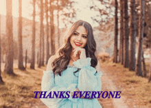 a woman in a blue dress stands in front of a forest with the words thanks everyone behind her