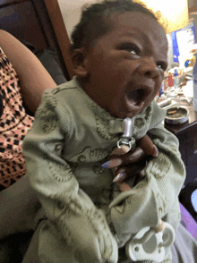 a baby with a pacifier attached to it is yawning