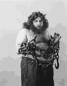 a man with a beard and chains around his arms