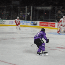 a hockey player in a purple jersey with the number 1 on the back