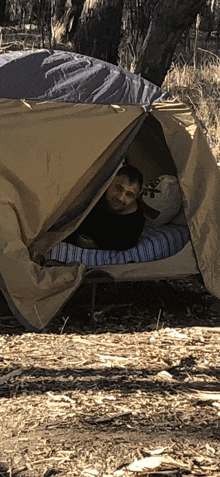 a man is laying in a tent with a pillow that says ' a ' on it