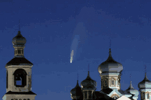 a comet is flying over a church with a bell tower