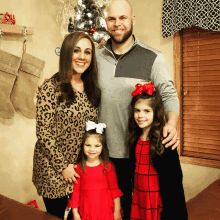 a family posing for a picture in front of christmas stockings