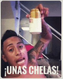 a man holds up a can of beer with the words unas chelas written below him