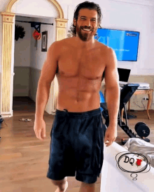 a shirtless man with a beard is smiling in front of a television