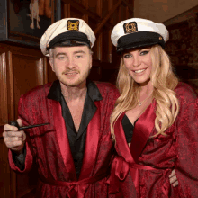 a man and a woman are dressed in captain hats and robes