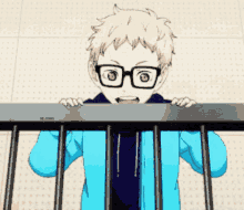 a boy wearing glasses and a blue jacket is standing behind a railing